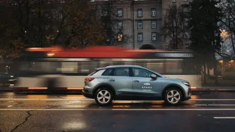 Spark A Spark electric car passes a tram